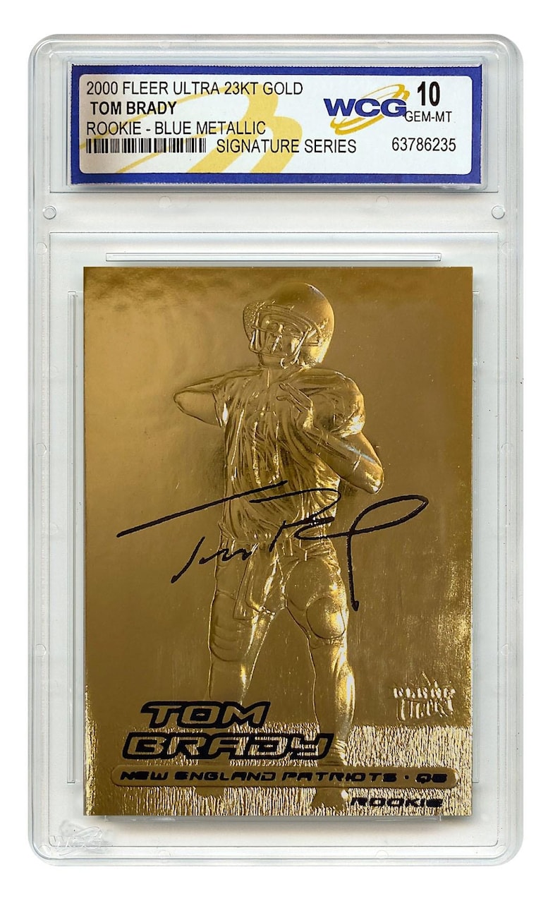 Puede incluir: Una tarjeta de novato de Tom Brady dorada de 2000 Fleer Ultra, calificada WCG 10. La tarjeta presenta un dise&ntilde;o de serie de firma azul met&aacute;lico y el texto "TOM BRADY" y "NEW ENGLAND PATRIOTS".
