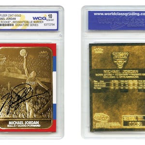 Puede incluir: Dos tarjetas de baloncesto doradas de Michael Jordan en estuches protectores. Una tarjeta presenta una imagen de Jordan lanzando una canasta con su firma. La otra tarjeta tiene el logotipo de los Bulls de Chicago e información del jugador.