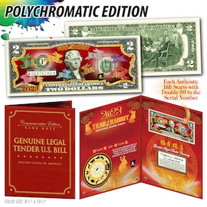 May include: A commemorative edition bank note featuring a two dollar bill with a colorful rabbit design. The bill is framed in a red folder with the text "2023 Year of the Rabbit" and "Genuine Bank Note".