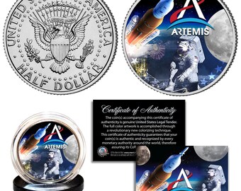 May include: A silver half dollar coin with the words "United States of America" and "Half Dollar" around the edge. The front of the coin features the American bald eagle with its wings spread. The back of the coin features a colorful image of an astronaut standing on the moon with a rocket ship in the background. The words "Artemis" are printed on the coin.