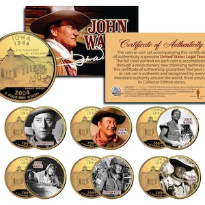 May include: A set of six gold-colored commemorative coins featuring images of John Wayne. The coins are surrounded by a certificate of authenticity that states the coins are genuine United States Legal Tender. The certificate also includes a signature from John Wayne.