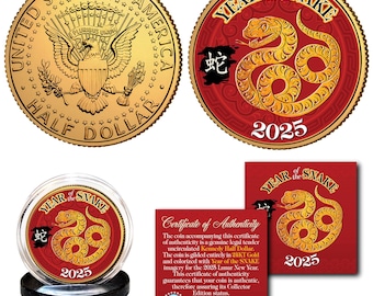 May include: A gold-coloured coin with a red and gold design featuring a snake and the text "Year of the Snake 2025". The coin is displayed in a clear plastic case with a black base.