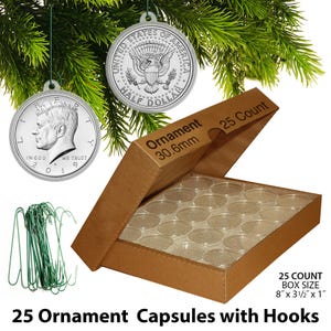 May include: A set of 25 ornament capsules with hooks, displayed with two silver coin ornaments hanging from a Christmas tree. The capsules are in a brown cardboard box, with the text "25 Count Box Size 8" x 3 1/2" x 1"" visible.