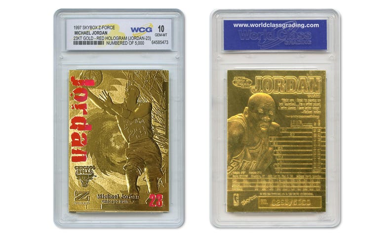 May include: Two gold-colored Michael Jordan basketball cards in protective cases. The front card features Jordan in action with the word "Jordan" in red. The back card shows a close-up of Jordan's face. Both cards are graded and numbered.