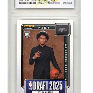 Può includere: Una carta Rookie Panini Instant 2025 di Dylan Harper, scelta n. 2 assoluta per i San Antonio Spurs. La carta è valutata WCG 10 GEM-MT e presenta Harper in un abito nero che tiene un pallone da basket.