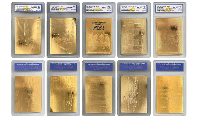 May include: A selection of gold-coloured Star Trek commemorative coins in protective cases. The coins display different designs and text, including the words "Commemorating 30 years of Star Trek".