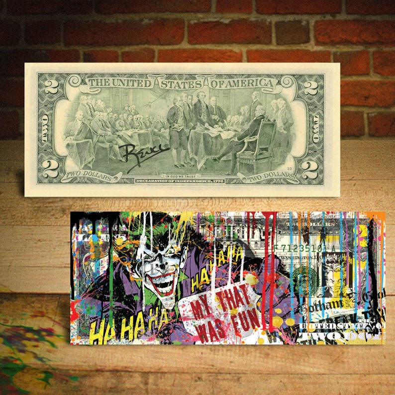May include: A two dollar bill with a colourful, abstract design featuring the Joker from Batman. The Joker is laughing and the text "My that was fun" is visible. The bill is splattered with paint in various colours, including red, yellow, blue, and green.