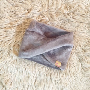 May include: Grey fleece headband with a small brown tag that says "Ira" on it.