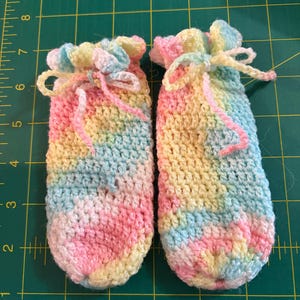 Scarpine da neonato a righe rosa, blu e gialle con fiocchetto in coulisse.