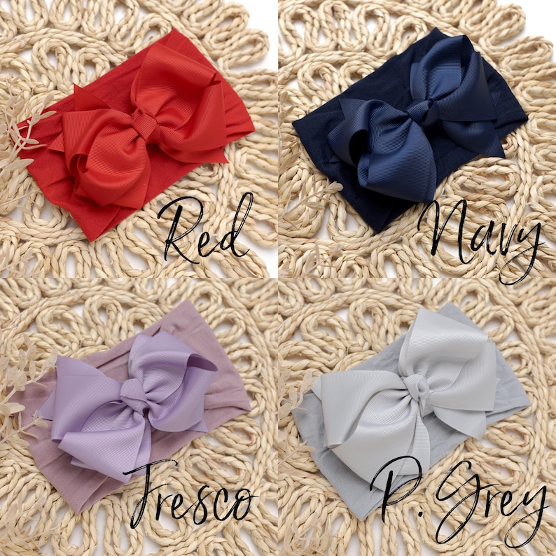 Peut inclure: Quatre bandeaux pour b&eacute;b&eacute;, rouge, marine, lavande et gris clair, chacun avec un grand n&oelig;ud. Les bandeaux sont pr&eacute;sent&eacute;s sur une surface beige tiss&eacute;e. Les couleurs sont &eacute;tiquet&eacute;es avec les mots "Red", "Navy", "Fresco" et "P. Grey".