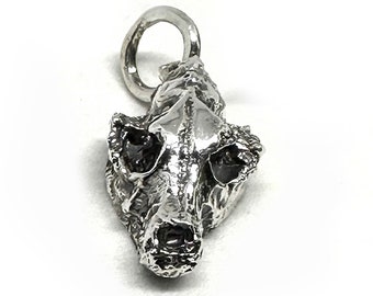 May include: A silver charm in the shape of an animal skull. The skull is detailed and realistic, with visible teeth and eye sockets.