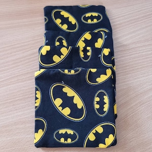 May include: Four black fabric pouches with a yellow Batman logo pattern.