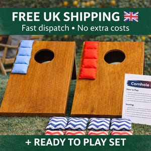 May include: Two wooden cornhole boards with circular holes, one featuring a stack of light blue bean bags and the other a stack of red bean bags. Below are eight additional bean bags with blue and white chevron patterns. A card titled Cornhole Rules is included.