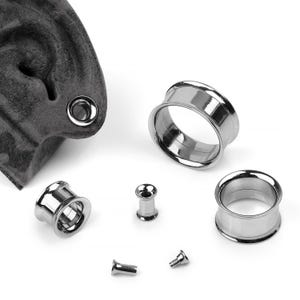 May include: A set of six silver-colored ear gauges in various sizes. The gauges are made of metal and have a smooth, polished finish.