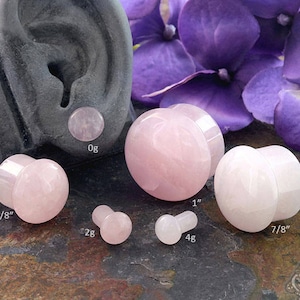 May include: A set of six pink rose quartz ear gauges in various sizes, ranging from 5/8 inch to 1 inch. The gauges are made of natural rose quartz and have a smooth, polished finish.