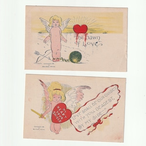 May include: Two vintage Valentine's Day postcards. One features a cherub with wings, a heart, and the text "The Dawn of Love." The other shows a cherub with a heart shield and the text "Love Shall Be Our Guide With You, Dearest, By My Side."