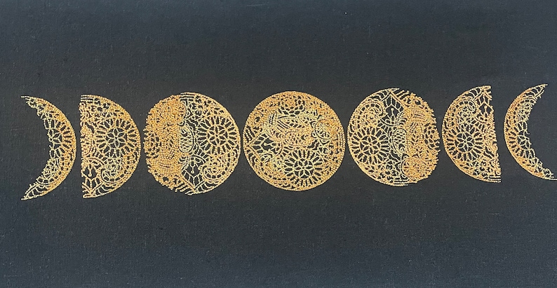 May include: A black fabric background with seven gold embroidered crescent moons, each with a different intricate design.