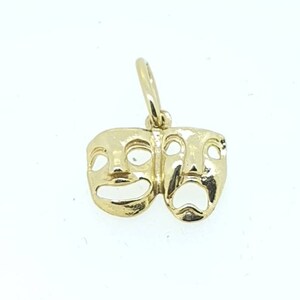 May include: Gold charm pendant featuring two theater masks, one smiling and one frowning.