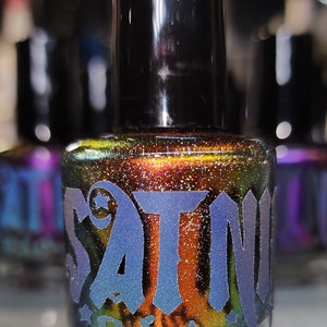 May include: A small bottle of nail polish with a dark brown base and iridescent glitter. The bottle is labeled "Satin Polish" in a blue and green font.