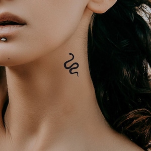 Peut inclure: Gros plan sur le cou d'une personne avec un petit tatouage de serpent noir.