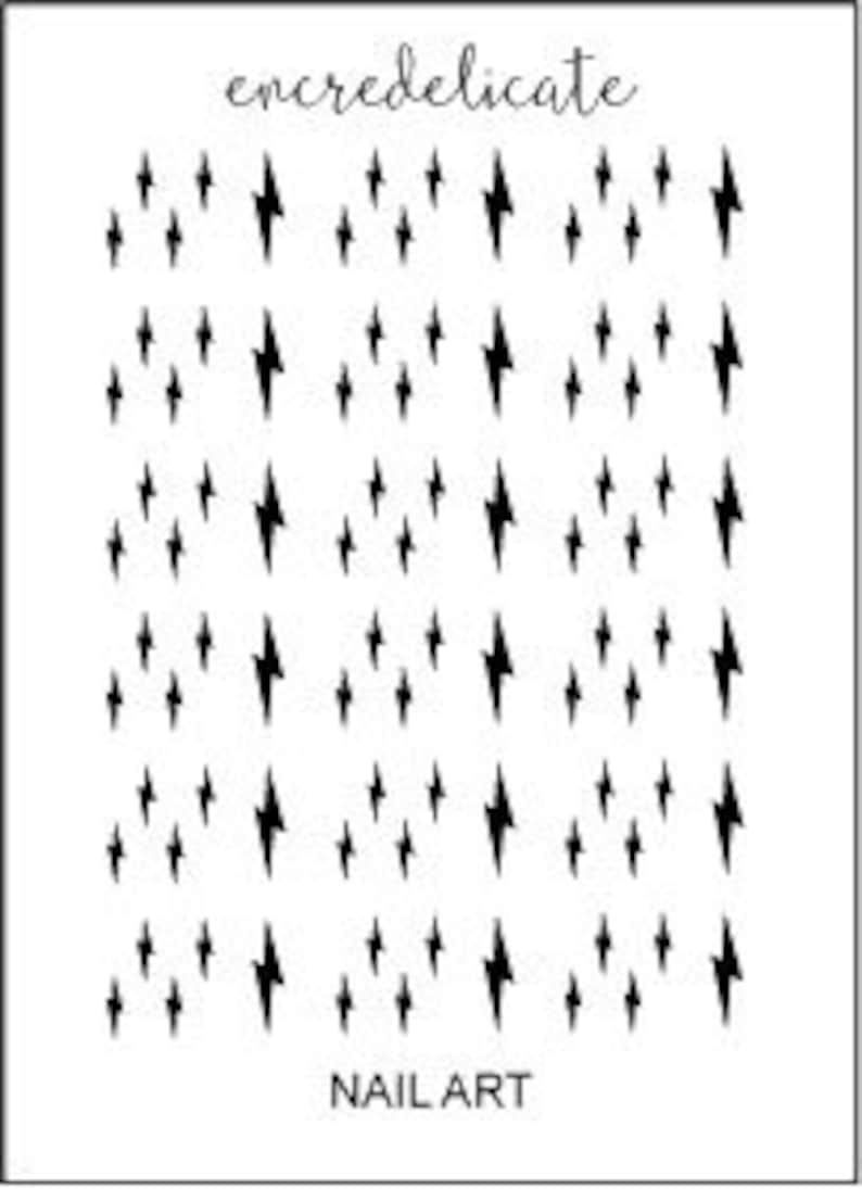 May include: Black and white nail art stickers featuring a repeating pattern of lightning bolts. The stickers are designed for use on fingernails.