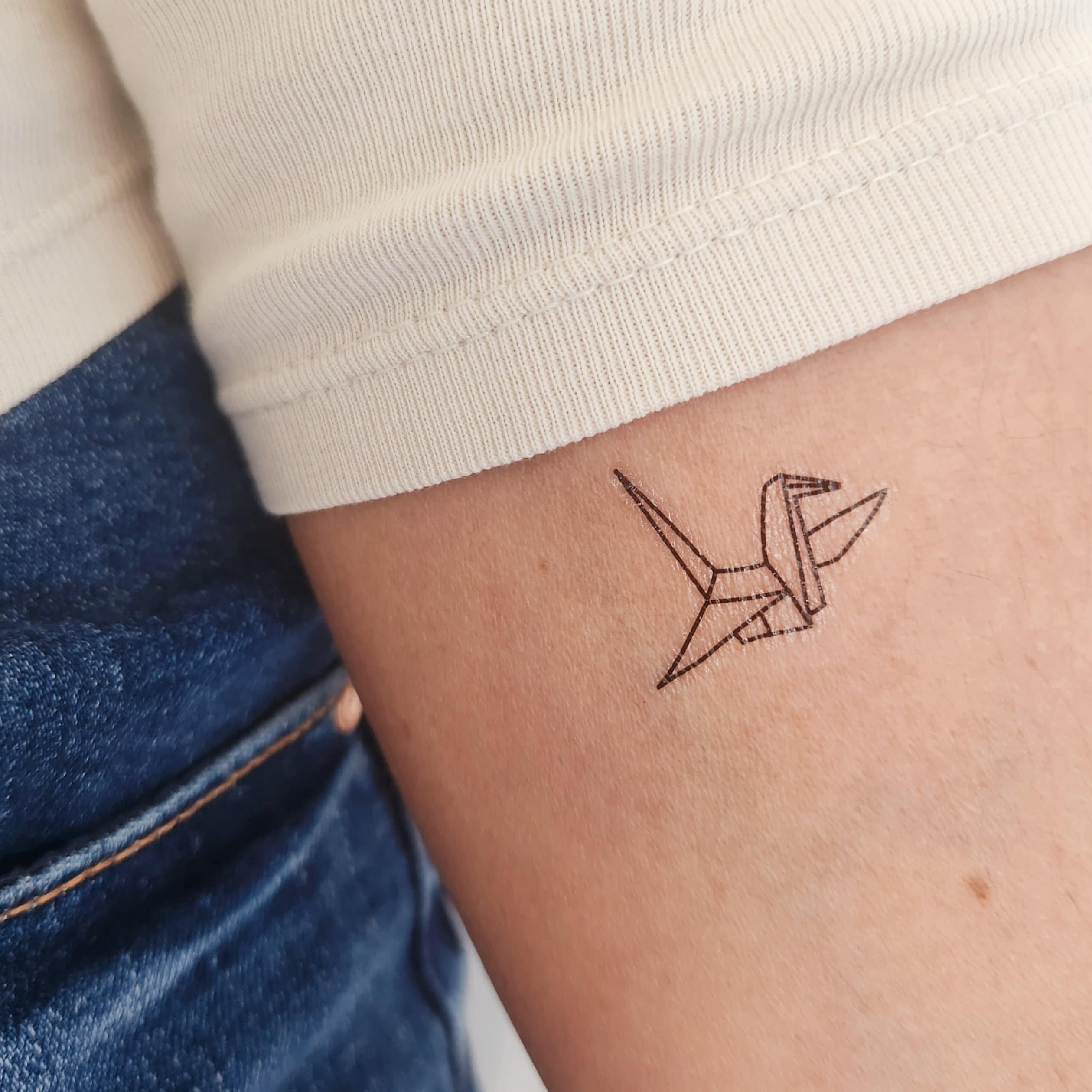Small origami crane on the ankle for poetic charm