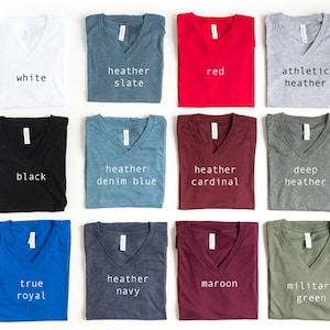 May include: A collection of 12 V-neck t-shirts in various colors, including white, black, heather slate, heather denim blue, heather cardinal, deep heather, true royal, heather navy, maroon, and military green. Each shirt has a different color and is labeled with its color name.