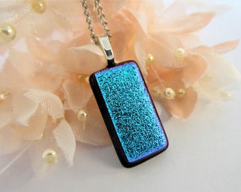 Teal green/black dichroic glass pendant with a textured pattern. Teal green-black fused glass necklace with crinkle texture.