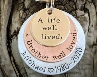 Può includere: Un portachiavi a strati in argento, rame e oro con il testo "A life well lived, a brother well loved. Michael ♥ 1980-2020"