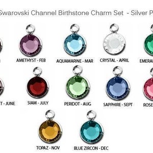 May include: A set of 12 silver-plated charms featuring Swarovski crystals in various colors, representing the birthstones for each month of the year. The charms are labeled with the month and birthstone name.