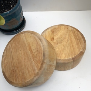 Peut inclure: Deux bols ronds en bois, l'un sur l'autre, tous deux en bois brun clair avec un motif de grain naturel.