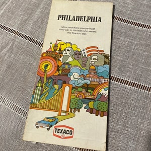 May include: Vintage Philadelphia travel brochure featuring colorful illustrations of landmarks and the text "More and more people trust their car to the man who wears the Texaco star." Includes the Texaco logo and a drawing of a car.