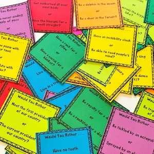 May include: A stack of colorful cards with the text "Would You Rather..." on each card. The cards feature various silly and thought-provoking questions.