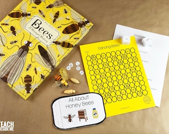 May include: A yellow and black bee-themed board game with a honeycomb board, dice, and game pieces. The game is called "Dancing Bees". There is also a book titled "Bees: A Honeyed History" and a small booklet titled "All About Honey Bees".