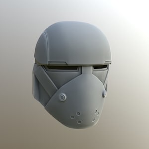 Könnte beinhalten: Ein grauer Plastikhelm mit Visier und Gesichtsmaske. Der Helm hat eine strukturierte Oberfläche und eine Reihe kleiner Löcher in der Gesichtsmaske.