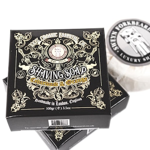 May include: A black box of cedarwood and orange shaving soap with gold lettering and a design of swords and a beard. The box is labelled "100% Organic Essential Oil" and "Handmade in London, England".