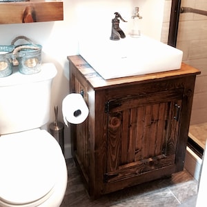 Rustic farmhouse half bath with the vessel sink vanity, floating shelves and a barnwood mirror cabinet