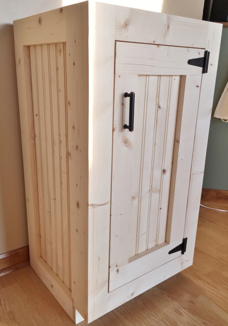Raw pine vanity base seen from the side, showing the beadboard side panel