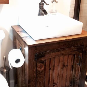 Rustic vessel sink vanity in dark walnut stain with a white vessel sink, planked pine top and oil-rubbed bronze hinges