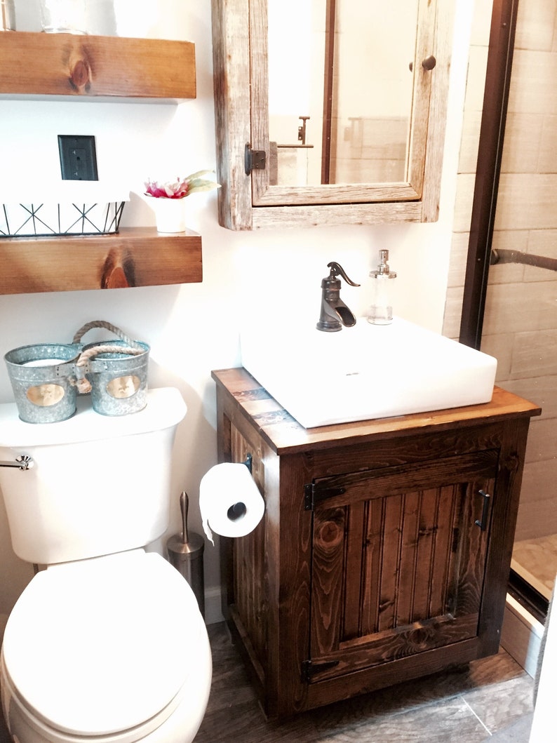 Rustic farmhouse half bath with the vessel sink vanity, floating shelves and a barnwood mirror cabinet