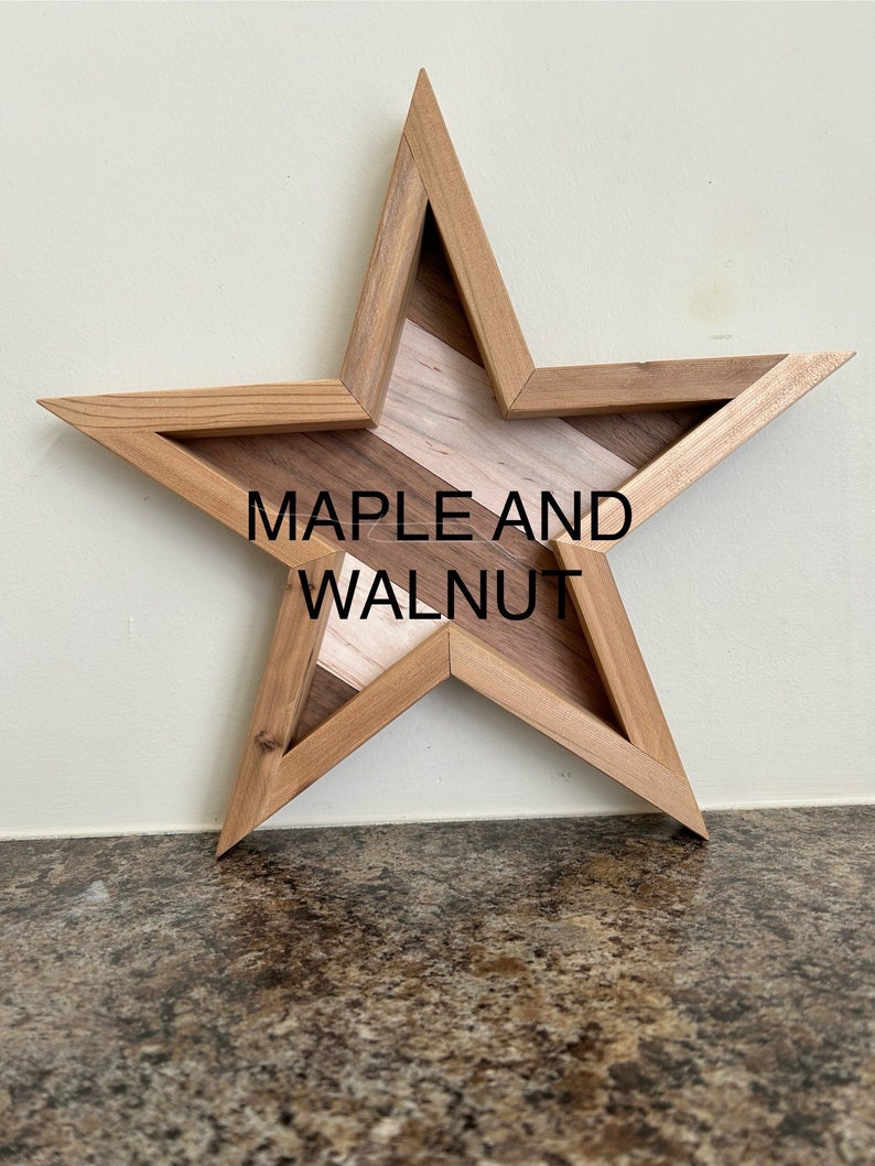 May include: A wooden star-shaped wall decoration with a maple and walnut inlay. The star is made of light brown wood and has a natural wood finish.