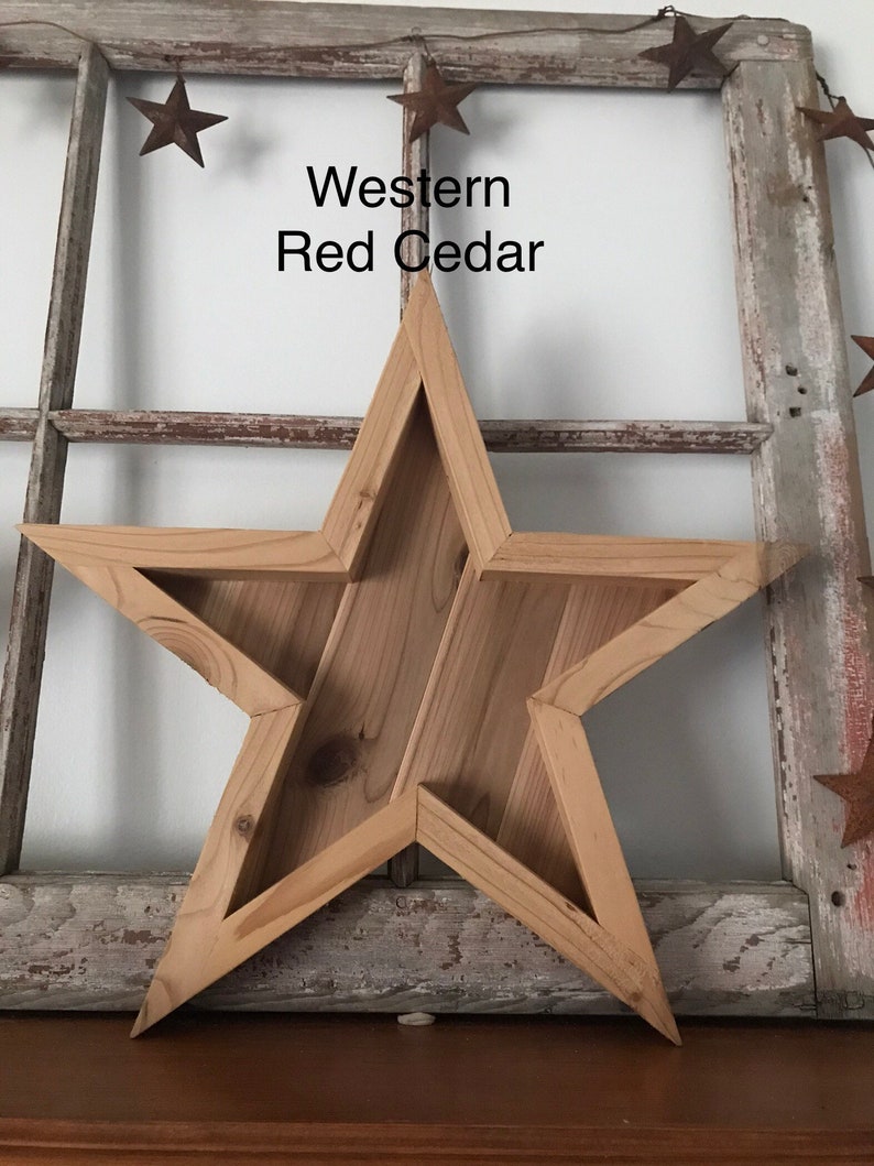 May include: A large wooden star-shaped wall decoration made of Western Red Cedar. The star is unfinished and has a rustic look.