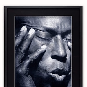 May include: Black and white poster featuring a close-up portrait of Miles Davis. The poster has the text "MILES DAVIS EN CONCERT" at the bottom.