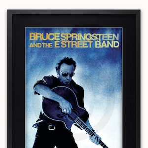 May include: A black and white poster featuring Bruce Springsteen and the E Street Band. The poster has a blue background with a white cloud-like design. Springsteen is playing a guitar and looking at the camera.