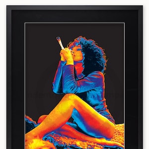 May include: A woman with curly hair sits on a textured surface, wearing a blue shirt and holding a lit cigarette. The image is in a thermal colour palette, with shades of red, orange, yellow, and blue.