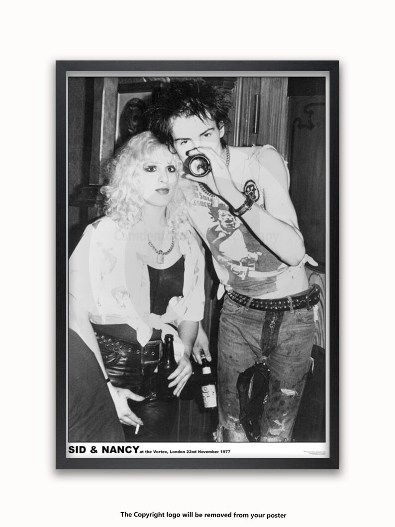 May include: Black and white photo of Sid Vicious and Nancy Spungen at the Vortex in London on November 22, 1977. Sid is holding a camera and Nancy is holding a bottle.