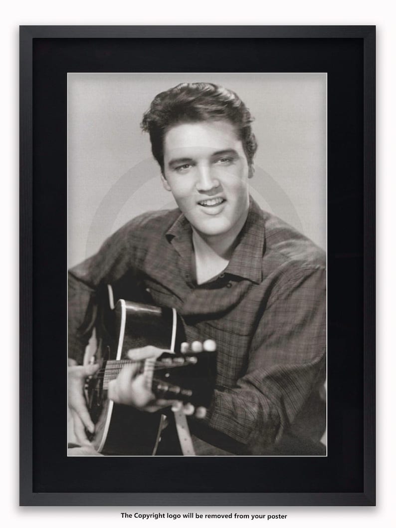 May include: Framed monochrome print of a man playing a guitar and smiling. The man wears a checked shirt. The print is in a black frame. The text at the bottom says "The Copyright logo will be removed from your poster."