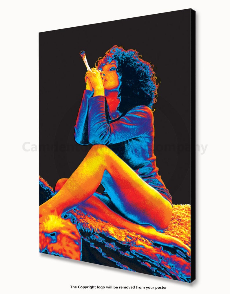 May include: A woman with curly hair sits on a textured surface, wearing a blue and orange outfit. She is holding a long, thin object to her lips.