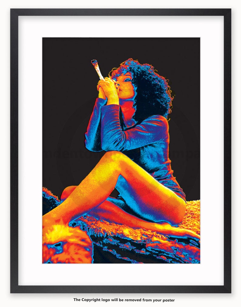 May include: A woman with curly hair sits on a rug, wearing a blue shirt and holding a lit cigarette. The image is in a thermal colour palette, with shades of red, orange, yellow, and blue.