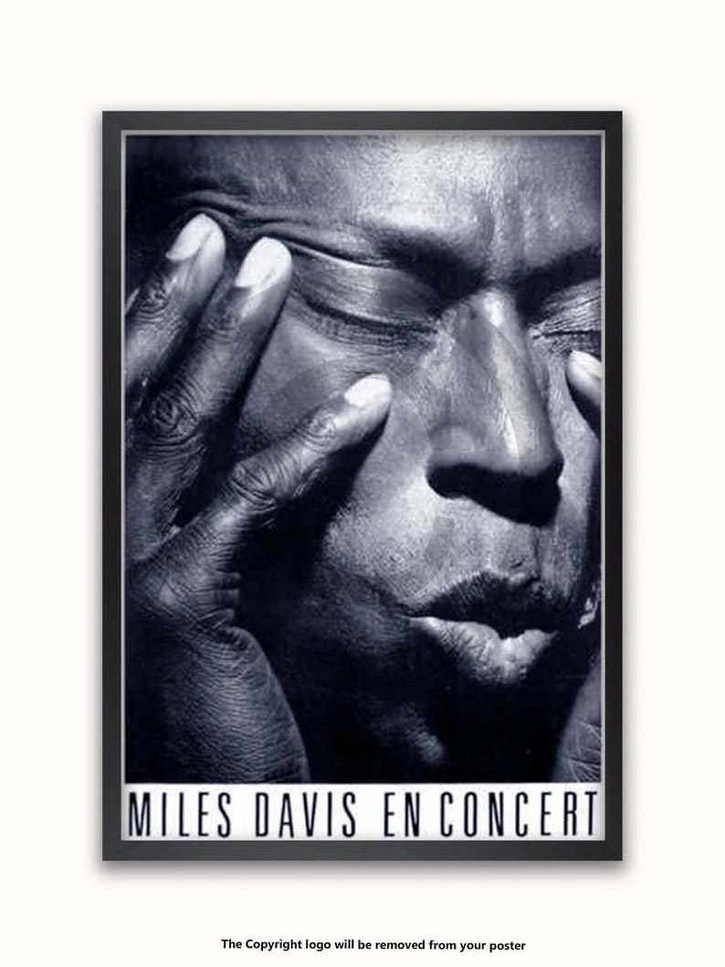 May include: Black and white close-up portrait of Miles Davis, a famous jazz musician, with the text "Miles Davis En Concert" at the bottom of the image.